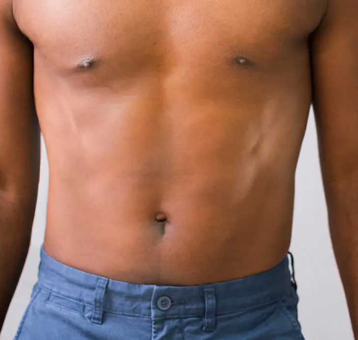 A man's toned, bare torso wearing blue shorts.