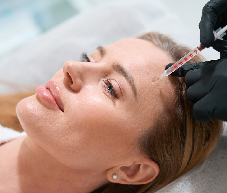Woman receiving facial injection in a clinical setting.