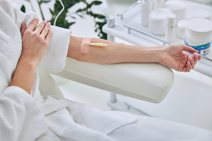 A person receiving an intravenous treatment in a clinic setting.