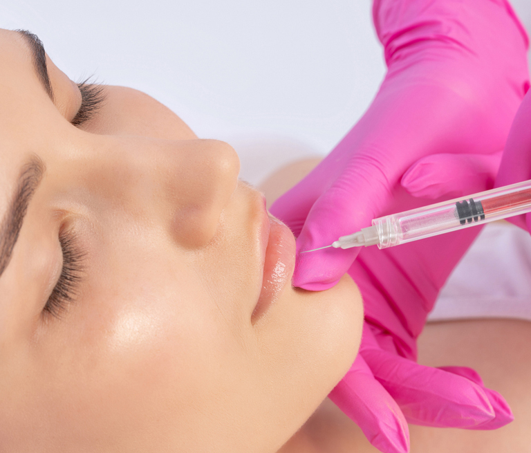 Person receiving lip injection with syringe in aesthetic treatment.