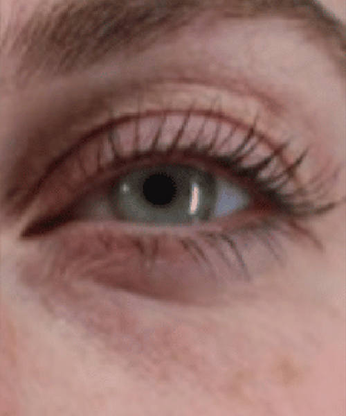 Close-up of a person's eye with long eyelashes and a neutral expression.