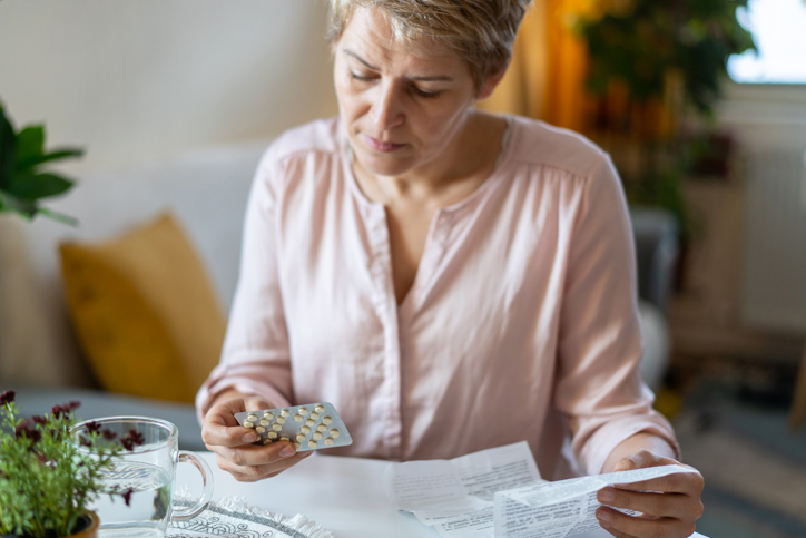 A woman reviews medication instructions at home.